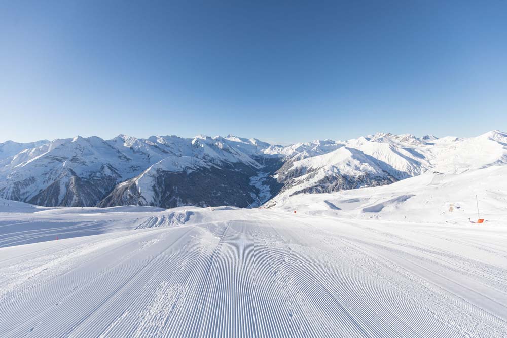 Rastkogel Skifahrer mit Tuxer Tal und blauem Himmel